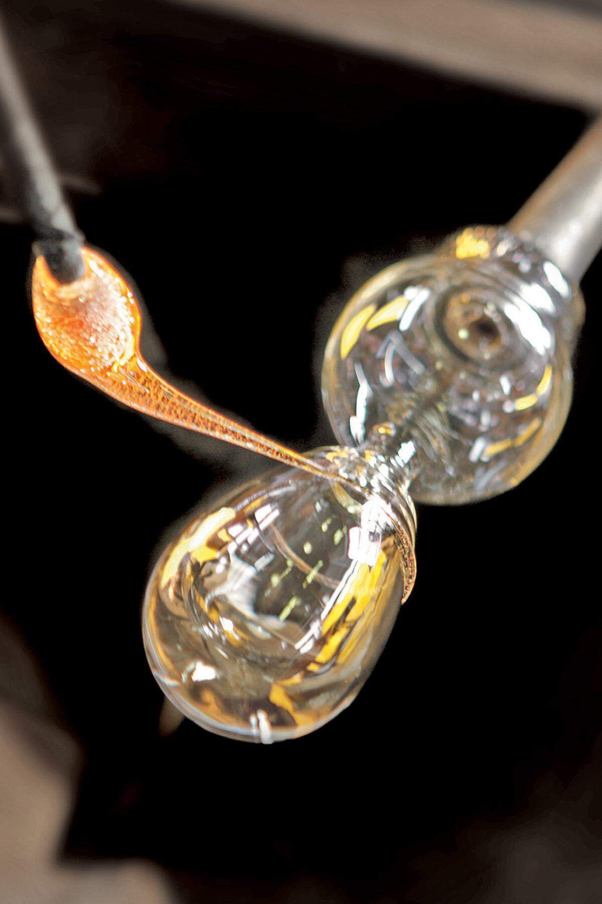 Solange das Glas noch flüssig ist, wird ein spiralenförmiges Ornament aufgetragen.