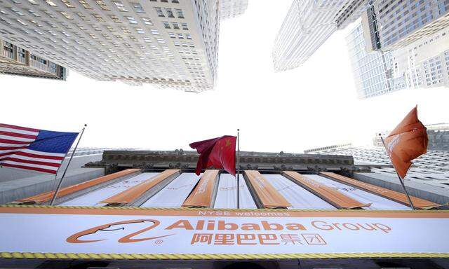 People stand outside of the New York Stock Exchange before Alibaba begins trading on Wall Street in