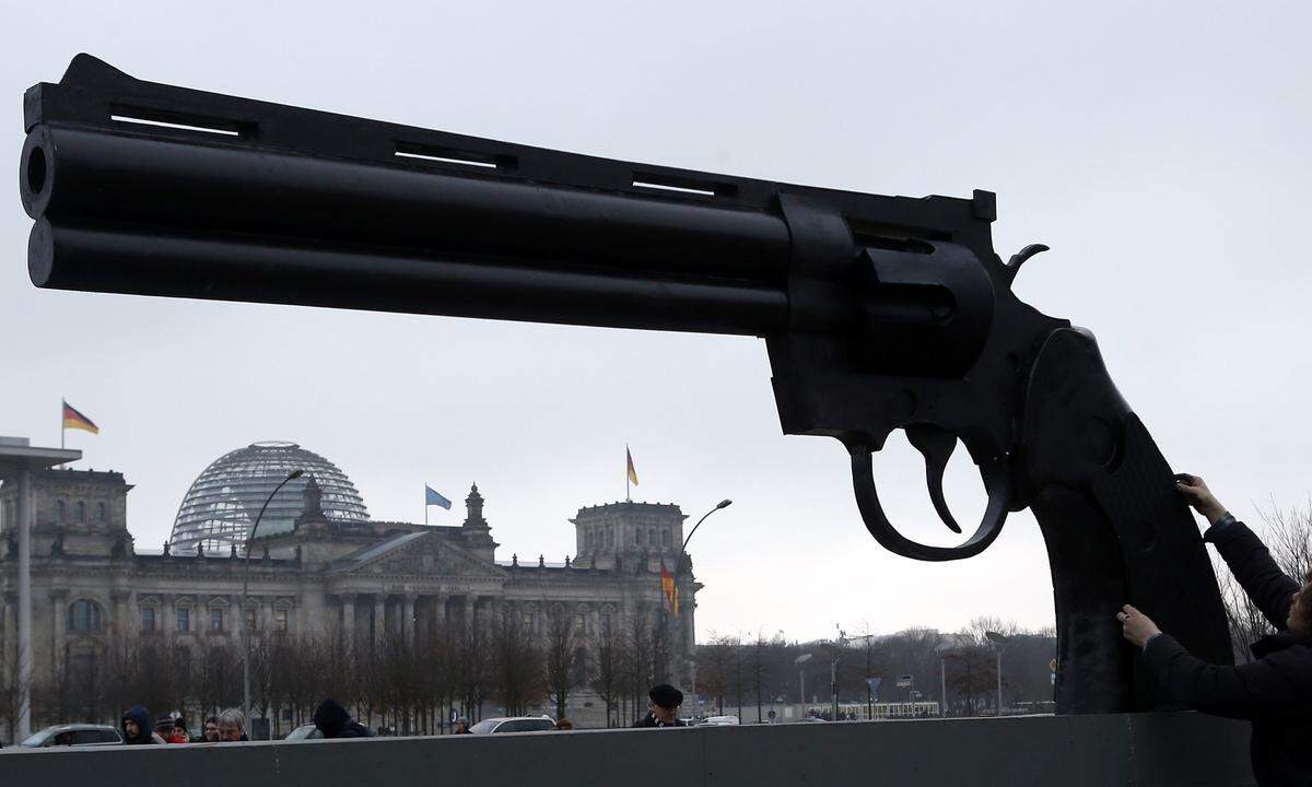 Die deutsche Friedensinitiative "Aktion Aufschrei - Stoppt den Waffenhandel" protestiert vor dem Reichstag in Berlin mit einer Pistolenskulptur - inspiriert vom schwedischen Künstler Carl Frederik Reutersvaerd.