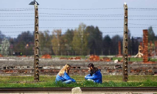Zwei junge Mädchen vor den Anlagen des Vernichtungslagers Auschwitz. 