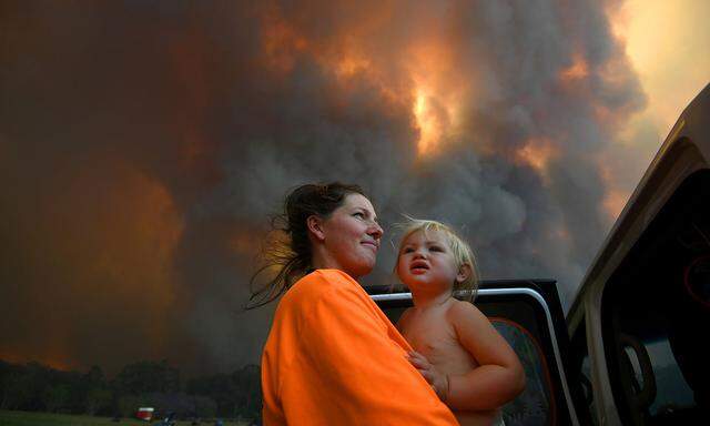 Eine Mutter mit ihrem Kind auf der Flucht vor dem Feuer.