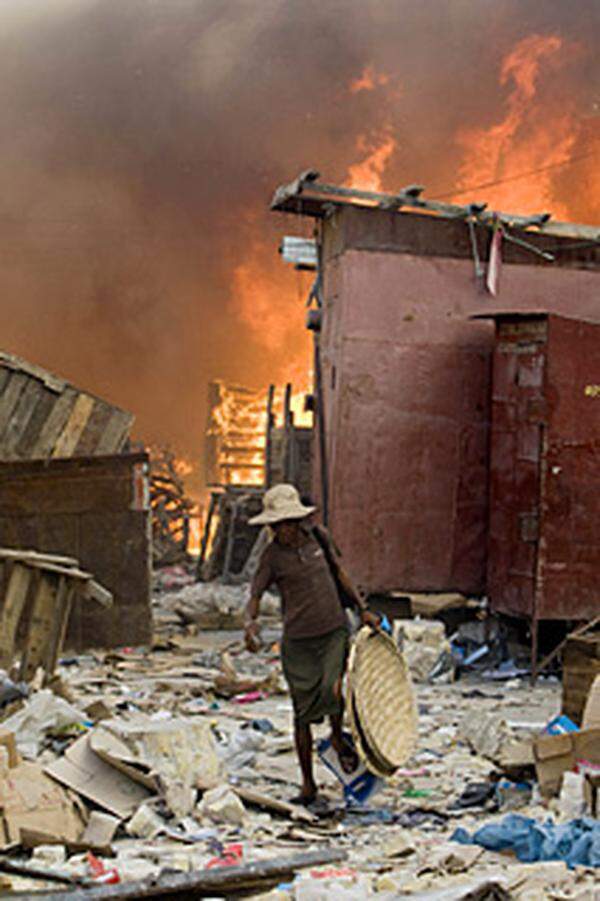 Im Bild: Ein Mann geht am 29. Jänner über einen Markt in Port-au-Prince, auf dem ein feuer ausgebrochen ist.