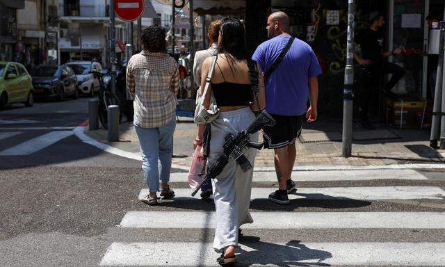 Eine Frau geht bewaffnet spazieren: Straßenszenen am Sonntag in Tel Aviv, einen Tag nach dem massiven Drohnenangriff des Iran. 