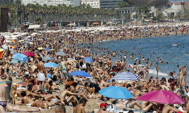 People cool off at Sant Sebastia beach in Barceloneta neighbourhood in Barcelona