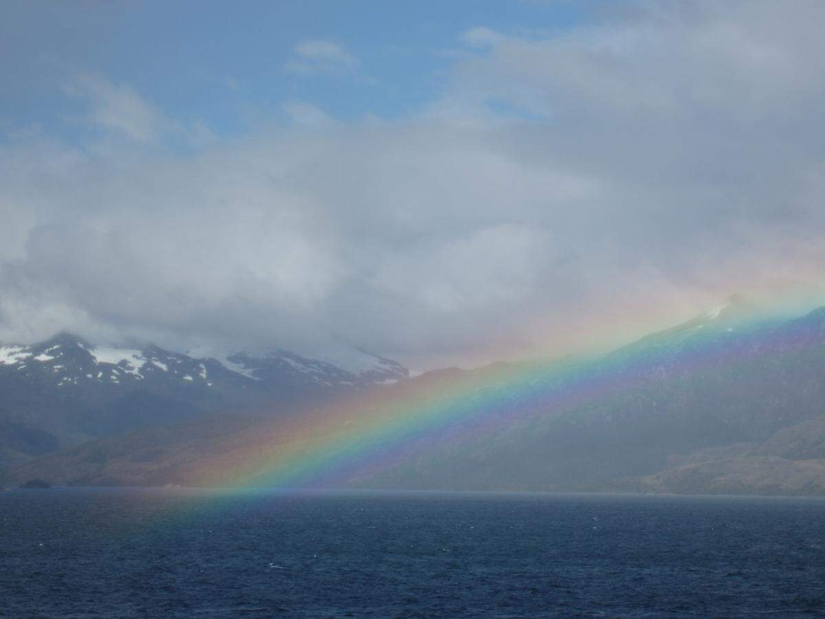 Unberechenbares Patagonien: meistens grau, plötzlich tauchen aus dem Nichts Zacken und Zinnen der Gebirge auf – und manchmal auch ein Regenbogen.