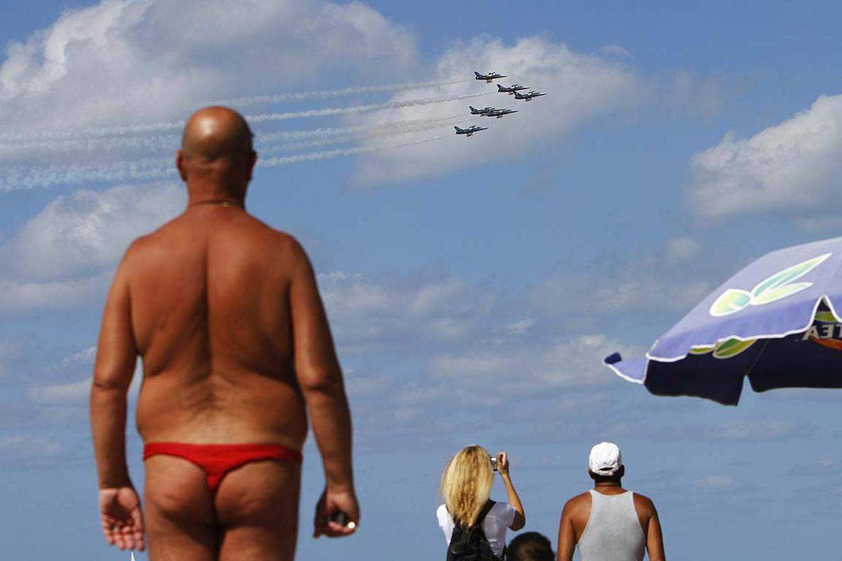 Tel Aviv, Israel. Das Breitling Jet Team zeigt am Himmel sein können, während die Urlauber die Abkühlung im Mittelmeer suchen.