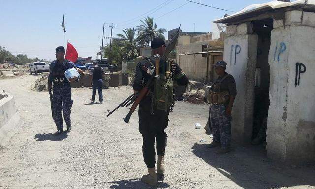 Members of the Iraqi security forces take part in an intensive security deployment at a checkpoint in the city of Baquba