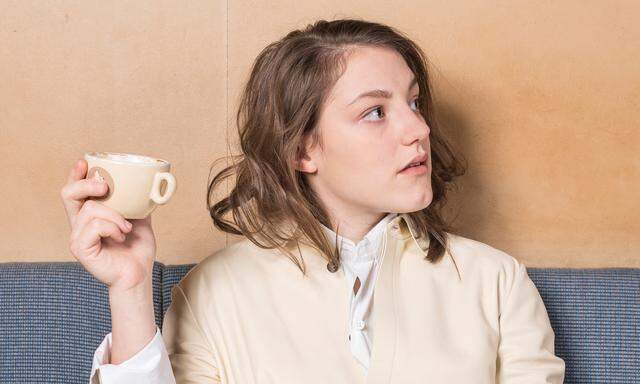 Sophie Stockinger trägt ein Kleid und einen Mantel von Jil Sander.  Die Aufnahmen entstanden im Café Weidinger am Lerchenfelder Gürtel.