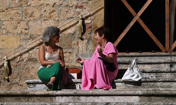 Symbolbild: Frauen unterhalten sich auf einer Treppe in San Gimignano, Toskana