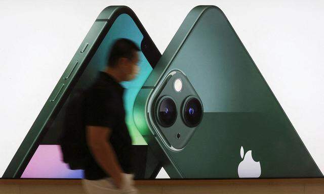 FILE PHOTO: A customer passes an Apple iPhone 13 advertisement at an Apple shop in Singapore