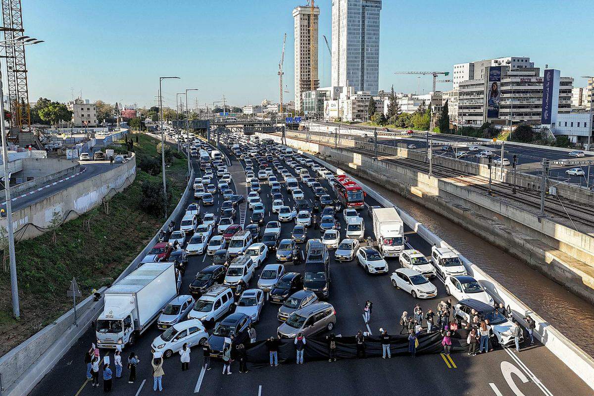 20. März. Angehörige von Geiseln, die seit dem 7. Oktober in der Gewalt der Hamas sind, blockieren in Tel Aviv aus Protest eine Straße.
