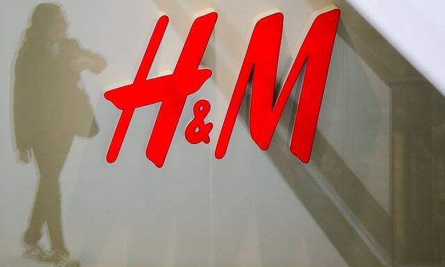 File photo shows a woman reflected next to logo of H&M fashion retailer in newly opened Mall of Berlin shopping centre in Berlin