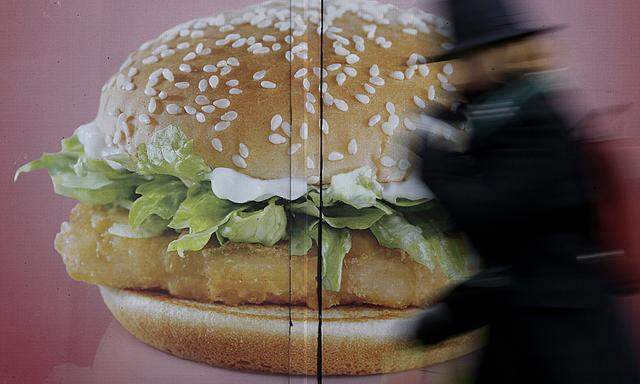A woman walks past an advertisement at a McDonald´s fast-food restaurant in Paris