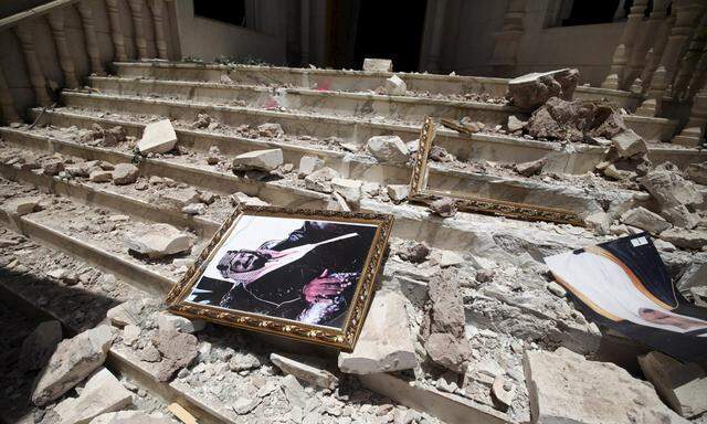 A picture of Saudia Arabia´s King Salman bin Abdulaziz lies amidst debris at damaged entrance to headquarters of Saudi Cultural Center in Sanaa, caused by April 20 air strike that hit nearby army weapons depot, in Sanaa