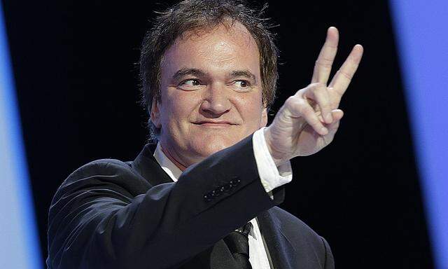 US director Quentin Tarantino flashes a victory sign as he arrives on the stage during the 39th Cesar Awards ceremony in Paris