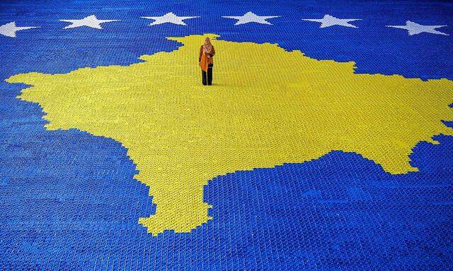 Herausforderndes Projekt Kosovo. Die Künstlerin Arbnora Fejza Idrizi auf ihrem gewaltigen Origami-Mosaik der Flagge des Kosovo in der Stadt Skenderaj.