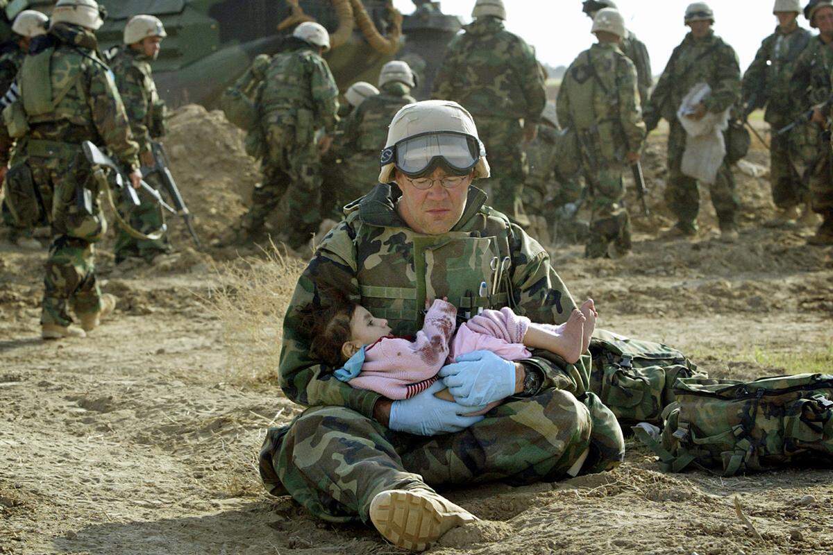 Ein US-Soldat tröstet ein irakisches Kind, dessen Familie bei einem Gefecht zwischen den US-Truppen und der irakischen Armee ins Kreuzfeuer gekommen war. Das schwer traumatisierte Mädchen überlebt als einzige.