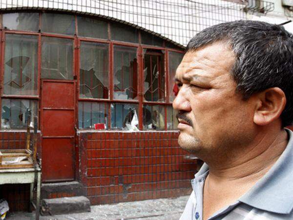 Ein uigurischstämmiger Mann geht auf diesem Foto gerade an einem Reaturant vorbei, das in der Nacht auf Mittwoch von wütenden Han-Chinesen beschädigt worden war.