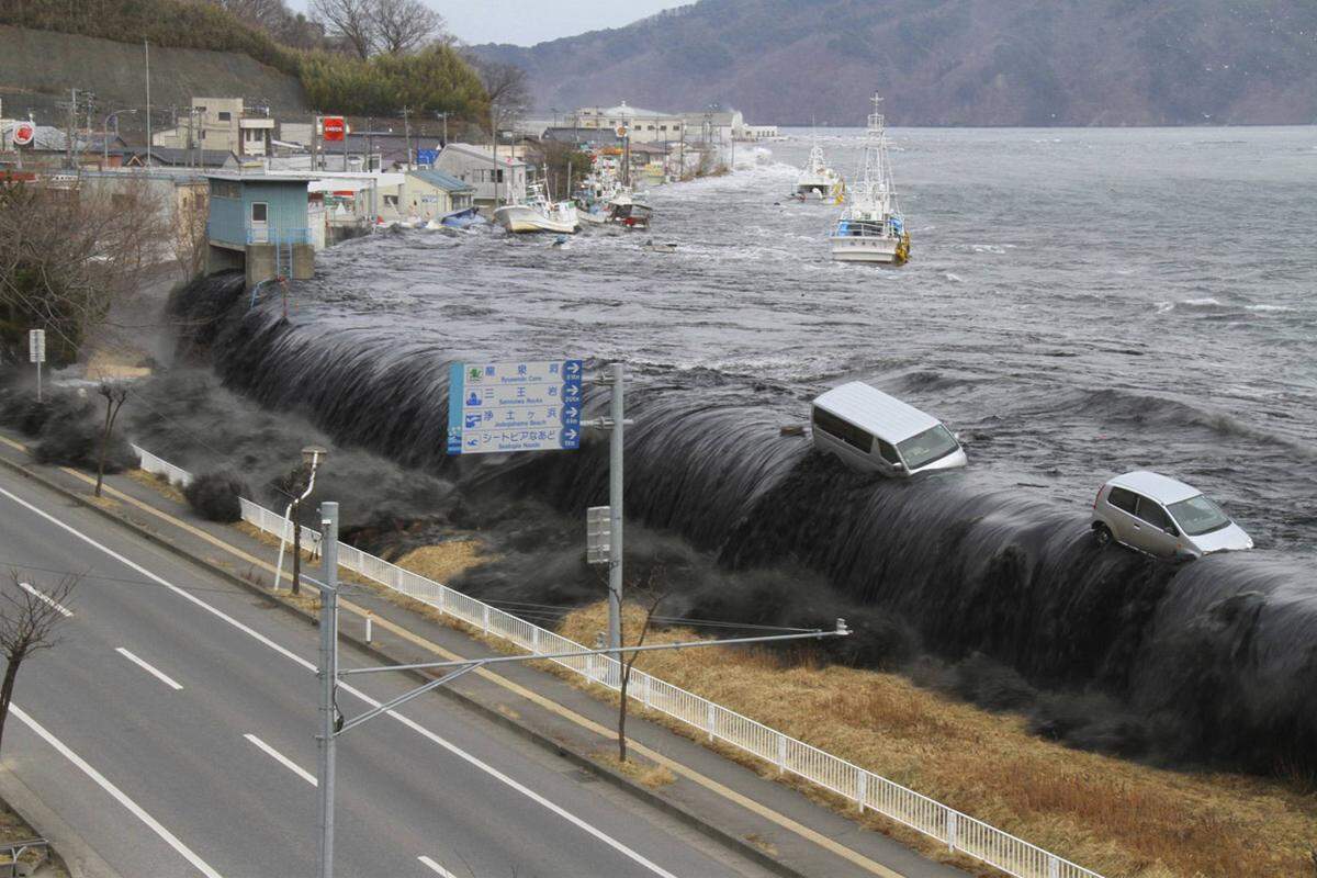 Am 11. März 2011 brach am frühen Nachmittag die Katastrophe über Japan herein. 130 Kilometer östlich der Stadt Sendai bebte die Erde. Es waren die schwersten Erdstöße, die Japan jemals trafen. Erdbebendienste ermittelten die Stärke 9,0. Rund eineinviertel Stunden später traf eine Flutwelle auf die Ostküste, die alles mit sich riss. Damit nicht genug: Im Atomkraftwerk Fukushima Eins fiel die Kühlung mehrerer Reaktoren aus, es kam zum GAU. Bild: In Miyako trifft die Flutwelle am 11. März des Vorjahres an Land.