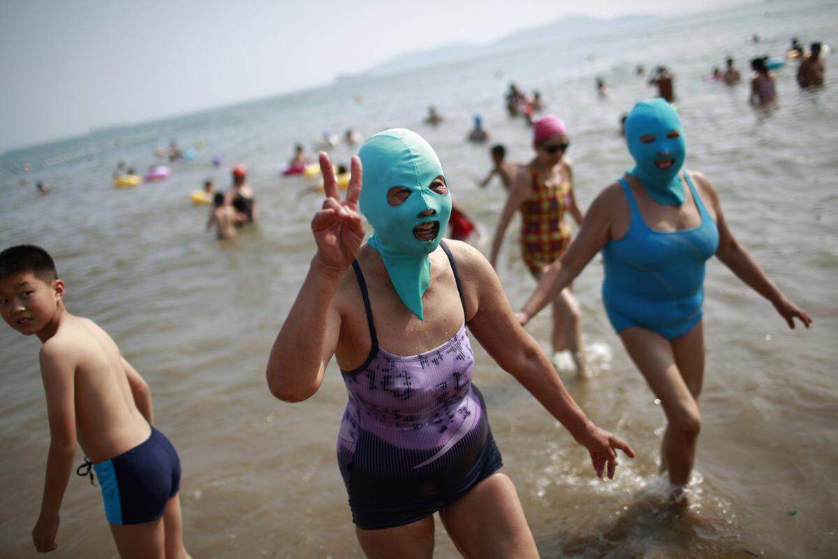 Am Strand von Qingdao in China schwören die Frauen auf einen textilen Sun-Blocker: Gesichtsmasken aus Nylon sollen den weißen Teint konservieren. Die Variante hat sich offenbar durchgesetzt, denn die Erfinderin hat die Gesichtsmasken bereits in die Masssenproduktion geschickt.