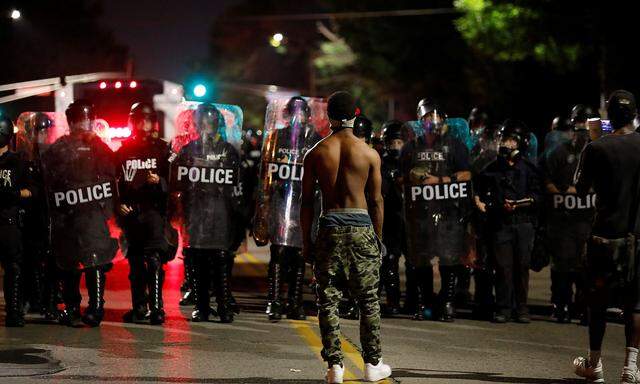 Einer der Demonstranten in St. Louis vor einer Reihe von Polizisten. Bei den Krawallen sollen zehn Polizisten verletzt worden sein.