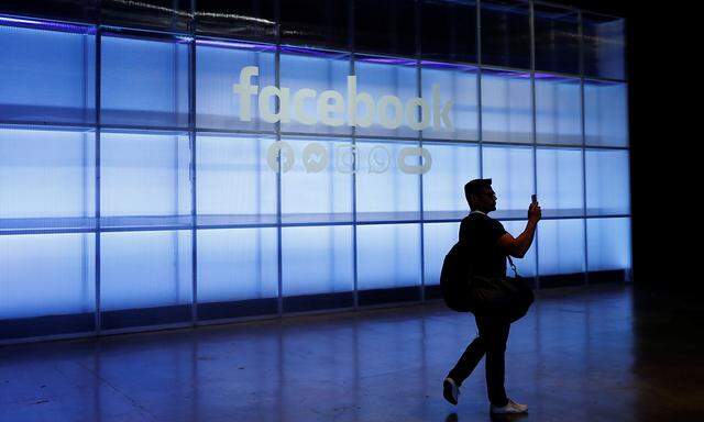 An attendee takes a photograph of a sign during Facebook Inc's F8 developers conference in San Jose