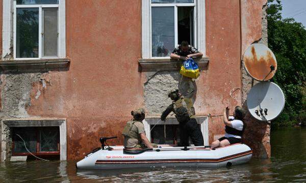 Ukrainische Soldaten versorgen in der Stadt Cherson vom Hochwasser Eingeschlossene.