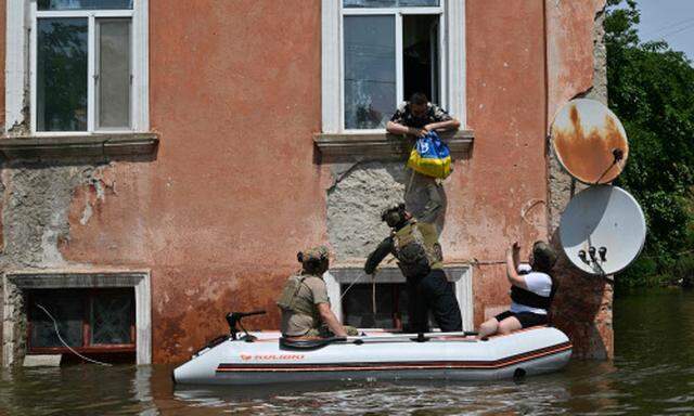 Ukrainische Soldaten versorgen in der Stadt Cherson vom Hochwasser Eingeschlossene.