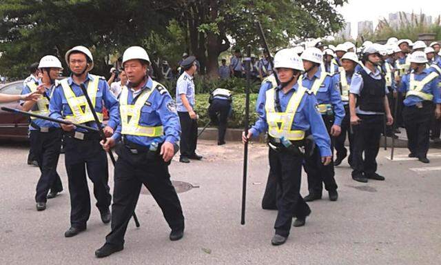 Handout shows policemen on patrol as workers go on strike outside a Yue Yuen factory in Dongguan