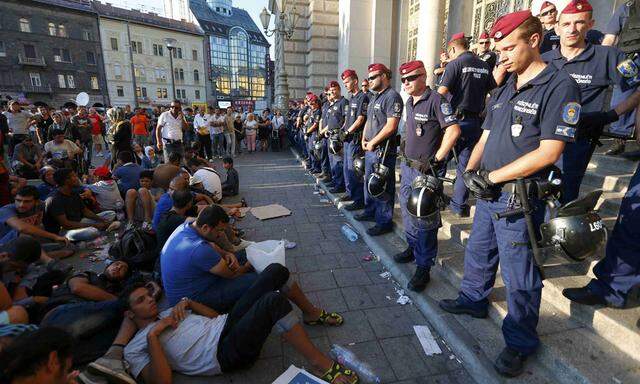 Migrants form a sit-down demonstration as police block the entrance to the main Eastern Railway station in Budapest