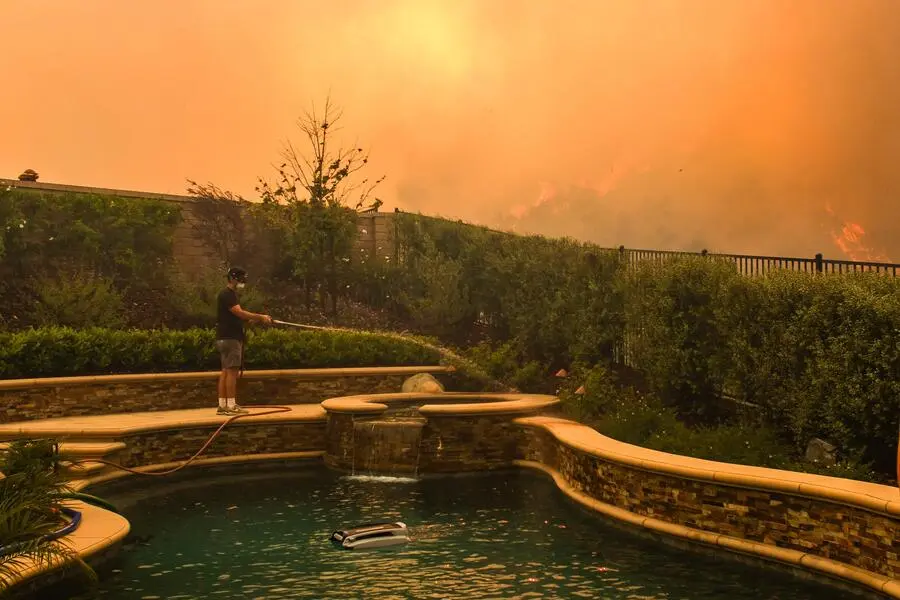 <strong>18. Mai. </strong>Nordwestlich von Los Angeles hat sich ein Waldbrand in der Umgebung der Stadt Simi Valley auf eine Fläche von rund 5,5 Quadratkilometern ausgebreitet. Ein Bewohner versucht, seinen Garten nass zu halten, bevor sein Haus evakuiert werden muss.