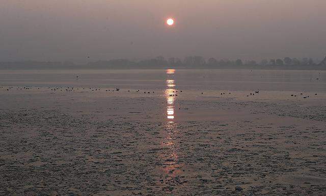 Sonnenaufgangsimpressionen am Strand von Travem�nde blick auf die trave mit eisschollen und den pr