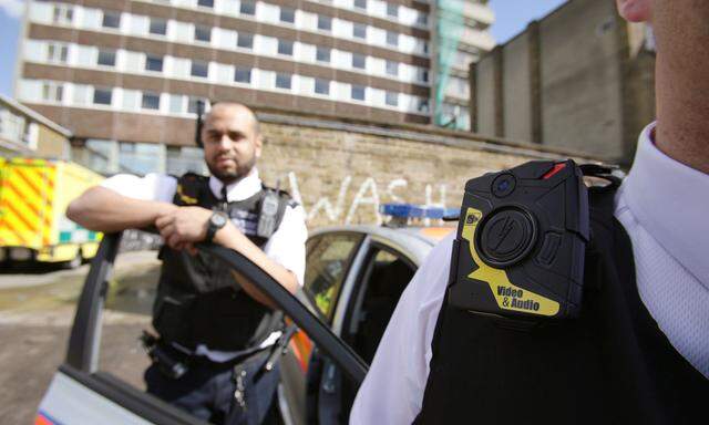 Police Constables Yasa Amerat and Craig Pearson pose for a photograph wearing a body-worn video camera, before a year-long trial by the Metropolitan police, at Kentish Town in London