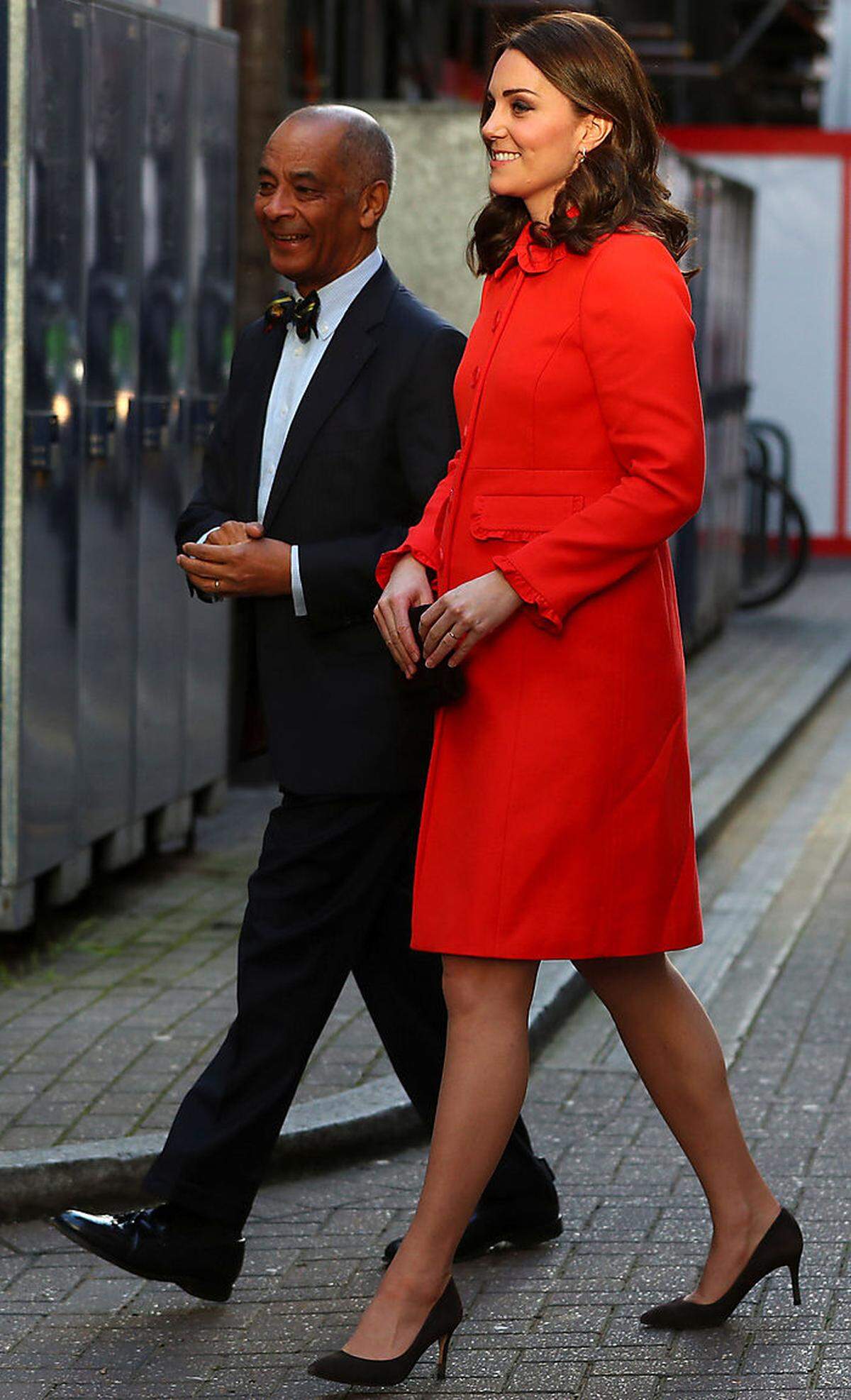 Der Rest des Outfits war eh ganz okay. Der orangerote Mantel vom britischen High-Street-Label Boden hätte uns ohne Rüscherl besser gefallen (die noch dazu zerdrückt aussahen). Die Abstimmung Orange-Braun-Pfirsich (siehe Unterkleid) ist zudem sehr altbacken. Ohrringe: Perlen von Annoushka, Stecker von Kiki McDonough. Frisur: very shiny.