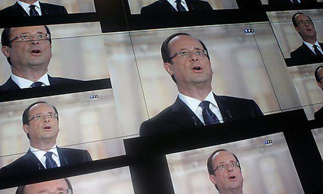Socialist Party candidate for the presidential election Francois Hollande, is seen on a wall screen d