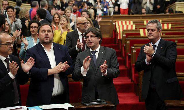 Der katalanische Regionalpräsident Carles Puigdemont (Mitte) und seine Verbündeten feiern die Parlamentsentscheidung. ties after voting to hold a referendum  in the Catalonian regional Parliament in Barcelona