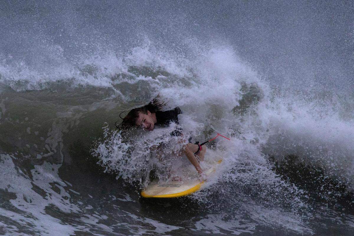 30. August. Ein Surfer reitet auf den Wellen vor Hurrikan Idalia in Clearwater Beach, Florida. (Aufgenommen am 29. August)