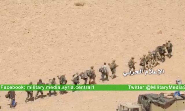Soldiers march in a line at where the Syrian military media said is Palmyra, in this still image taken from a Syrian military media video