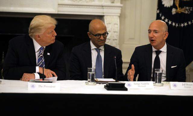 U.S. President Donald Trump and  Satya Nadella CEO of Microsoft Corporation listen as Jeff Bezos, CEO of Amazon speaks during an American Technology Council roundtable at the White House in Washington, U.S.