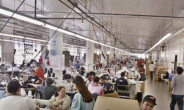 A worker moves several boxes of American Apparel garments on the sewing floor, April 12, 2004, in Los