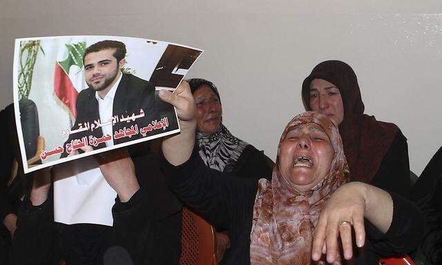 Mother of Hamza Haj Hassan holds his picture as she mourns his death in his home village in Shaath