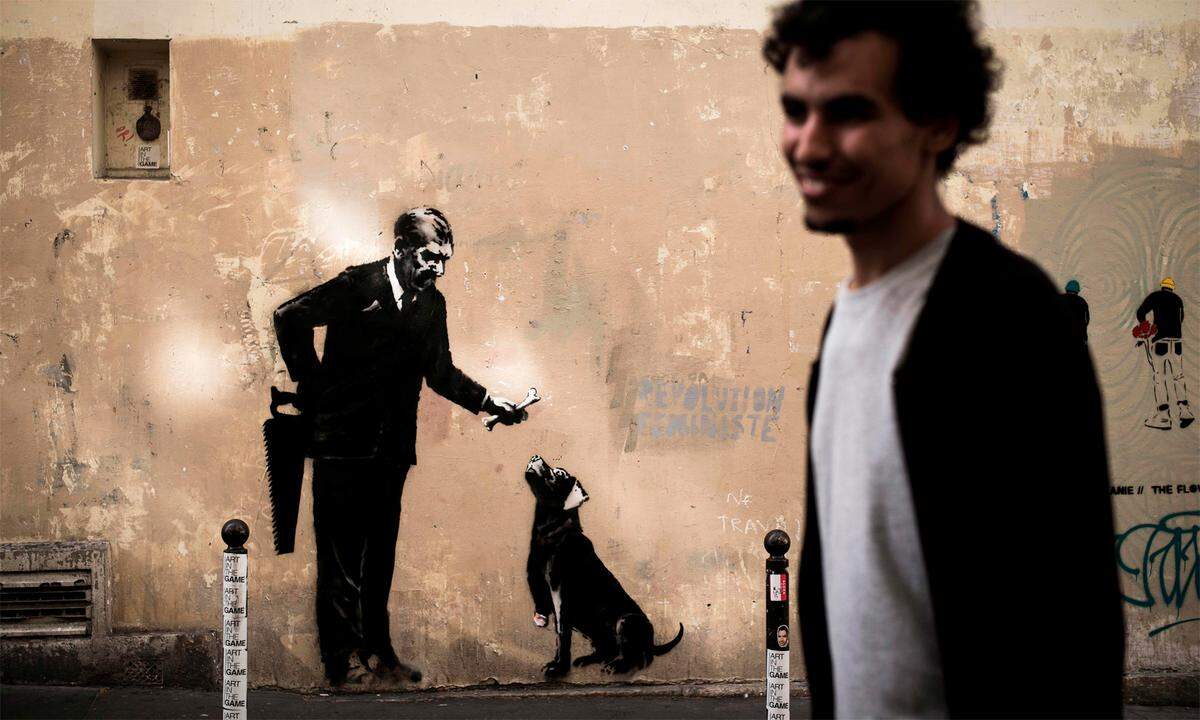 Auch in der Nähe der Universität Sorbonne wurde ein Bild entdeckt, das wahrscheinlich von Banksy stammt: Es zeigt einen Mann, der eine Säge hinter seinem Rücken versteckt und mit der anderen Hand einem Hund einen Knochen hinhält - dem Hund fehlt ein Stück eines Vorderbeins.