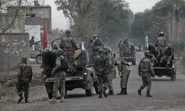Soldiers arrive and take position near the site of a police station after it was attacked in Bannu