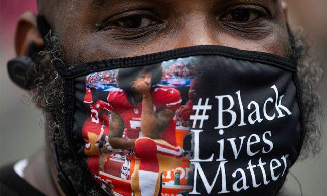 Der kniende Colin Kaepernick auf einer Gesichtsmaske eines Demonstranten.