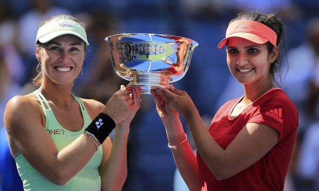 Hingis of Switzerland and Mirza of India hold their trophy after defeating Dellacqua of Australia and Shvedova of Kazakhstan in their women's doubles finals match at the U.S. Open Championships tennis tournament in New York