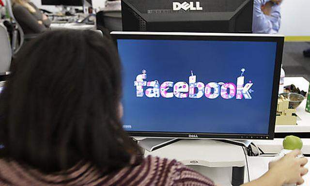 FILE -This Dec. 13, 2011 file photo, shows workers inside Facebook headquarters in Menlo Park, Calif.