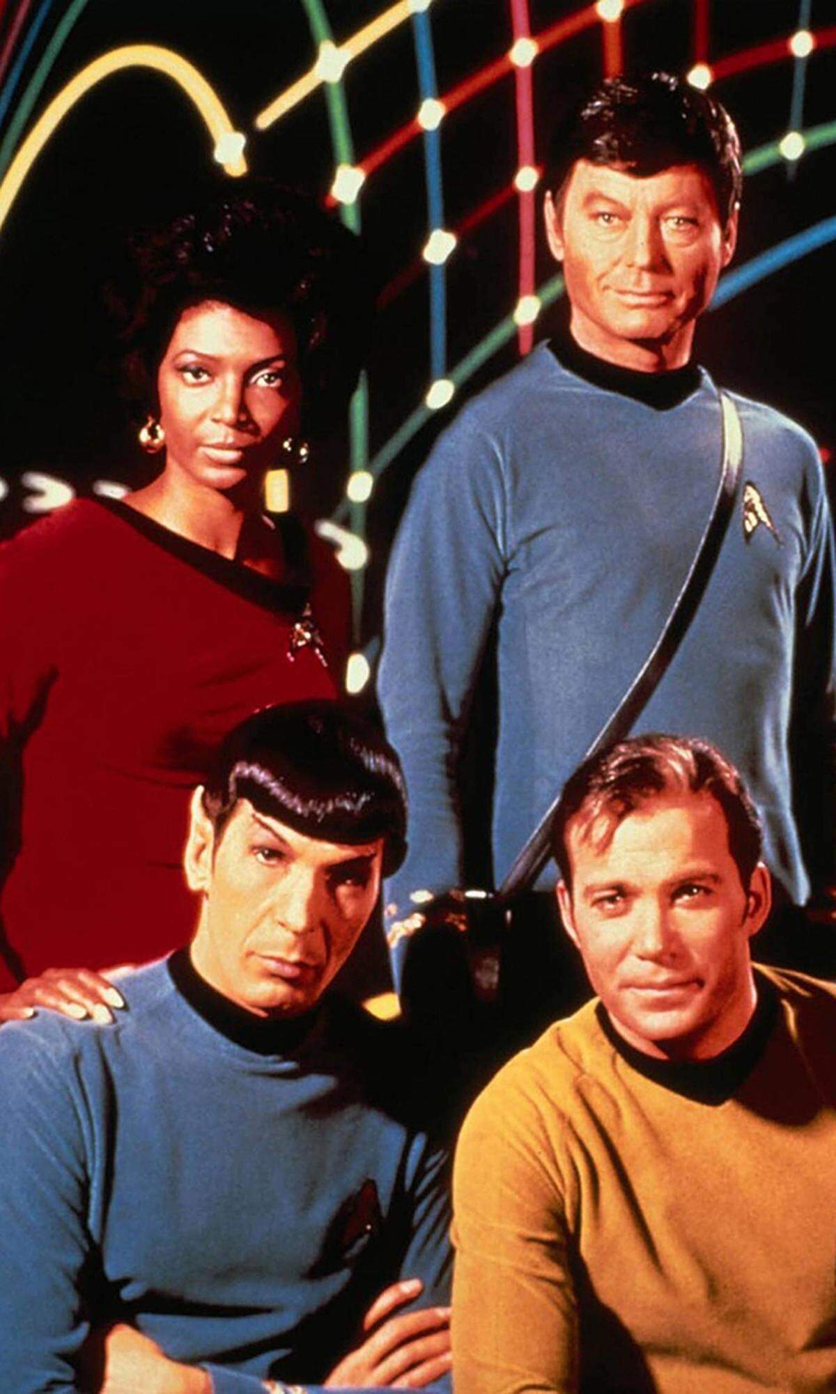 So sah die Crew der Enterprise 1967 aus:  Leonard Nimoy als Lieutenant Spock (vorne links), William Shatner als Captain James Tiberius Kirk (rechts vorne), DeForest Kelley als Dr. Leonard McCoy (hinten rechts), Nichelle Nichols als Lieutenant Nyota Penda Uhura (hinten links) 