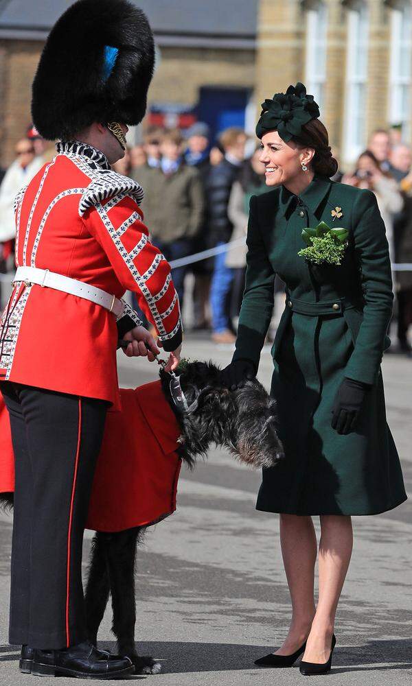 Wenn Prinz William und Herzogin Kate bei einer Parade mit den Irish Guards in London den St. Patrick’s feiern, dann stehen die Wettquoten auf Catherine's Kleiderfarbe ganz schlecht bzw. auf ganz Grün. Und auch heuer hat sie uns in einem smaragdgrünen Mantel von Alexander McQueen mit passendem Pillbox-Hut nicht enttäuscht. Die Kleeblatt-Brosche an ihrer Brust stammt vermutlich von Cartier und wird von der Garde an weibliche Mitglieder der königlichen Familie verliehen. Bleibt noch die Klärung der Tasche („Roxy“-Clutch von Jenny Packham), der Schuhe (Pumps von Gianvito Rossi), ihrer Ohrringe (grüne Hängeohrringe von Kiki McDonough) und des Namen des Maskottchens der Garde (der Irische Wolfshund hört auf „Domhnall“).