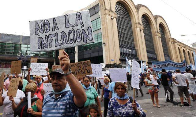 A demonstrator holds up a sign during a protest outside a Coto supermarket in Buenos Aires
