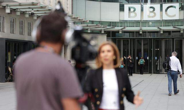 Ein Reporter der BBC bei der Arbeit vor dem  Londoner Hauptquartier der British Broadcasting Corporation, die im Vorjahr 100 Jahre alt wurde.